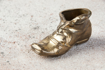 Naklejka premium Old brass ashtray in the shape of a shoe