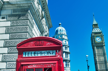 Fototapeta na wymiar London phone booth with buildings and Big Ben on the background