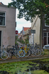 Fototapeta na wymiar ten bicycles tied together at the edge of a canal in a Dutch town in summer