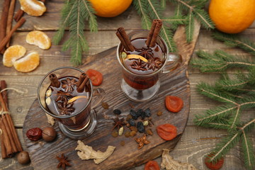 mulled wine hot drink or tea with spices and spices on a wooden background with a branch of spruce. Traditional winter drink. Christmas concept, background, banner, menu. Top view. Flat lay.