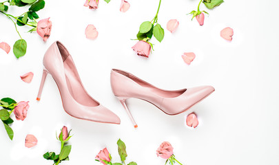Pale pink female shoes on white background. Flat lay, top view trendy fashion feminine background....