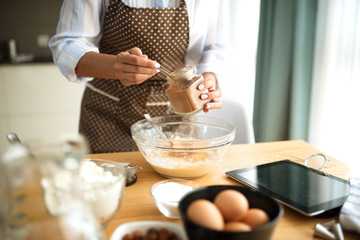Young woman in the kitchen and inserts ingredients