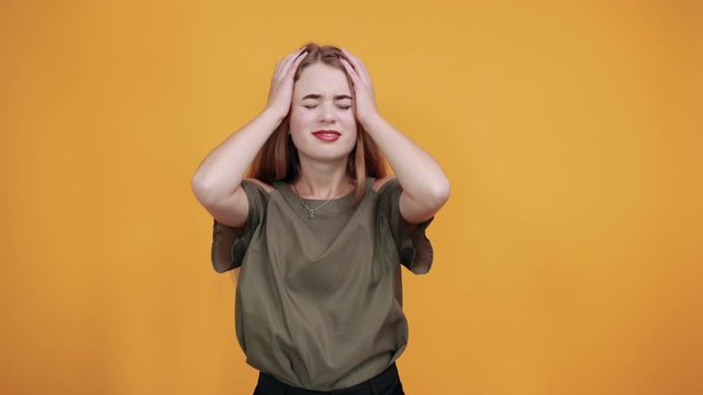 Young funny beautiful caucasian woman wearing nice shirt puffing cheeks and keeping fingers on with angry face. Crazy expression