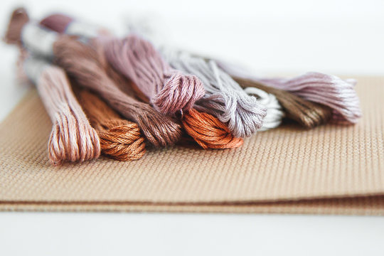 flatlay creativity: canva aida beige and multi-colored thread mouline thread, cross-stitch 