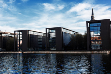 Fototapeta na wymiar BUSiNESS CENTER IN COPENHAGEN, DENMARK. Row of modern buildings near the river.