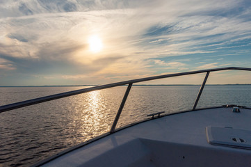 Side view of a fishing boat and the St. John's river, close to sunset, on a cloudy and sunny afternoon. Jacksonville, Florida, USA