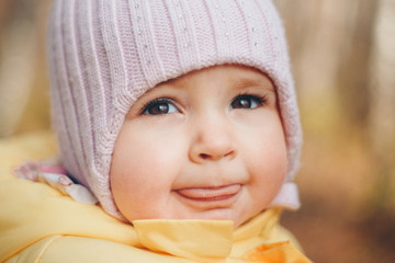 a little girl in a warm hat on his head smiled. the concept of childhood, health, IVF, cold time