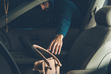 a thief steals bag in car