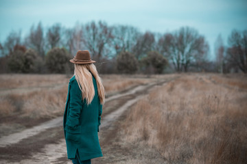 Woman of plus size, American or European appearance walks at the nature. A young lady with excess weight, stylishly dressed in warm clothes, Natural beauty