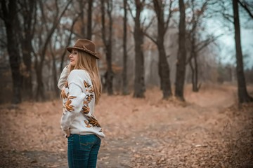 Woman of plus size, American or European appearance walks at the nature. A young lady with excess weight, stylishly dressed in warm clothes, Natural beauty