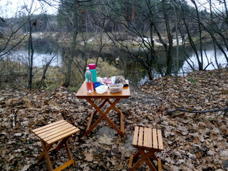 Lunch by the river in a pine forest in autumn