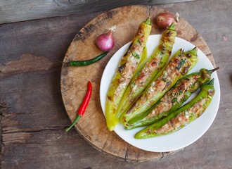 Grilled peppers stuffed with minced pork on wooden background. Thai food 