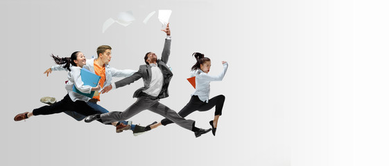 Happy office workers jumping and dancing in casual clothes or suit with folders on white. Ballet...