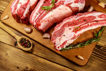 Raw pork ribs with spices, garlic and rosemary on wooden table. Top view