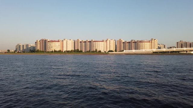 Panorama of the embankment of the Neva River at sunset. View from the ship. The passenger person looks at the old and modern architecture from a cruise ship.
