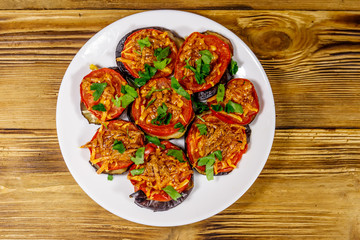 Baked eggplants with tomatoes and cheese on wooden table. Top view