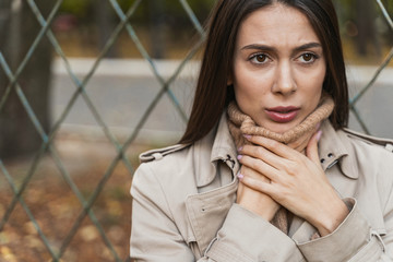 Attractive brunette female person suffering sore throat