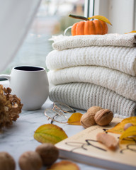 Warm clothes stacked on the window with a Cup of coffee.