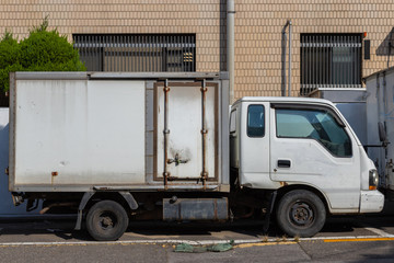 An old truck. White grocery lorry. Small rusty refrigerator vehicle. Logistics Marketing.