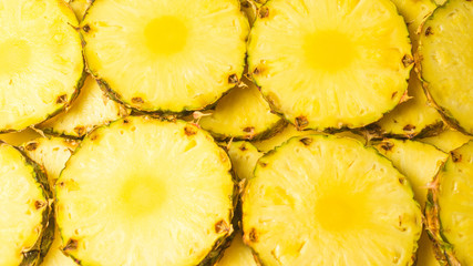 Pineapple juicy yellow slices background. Top view.