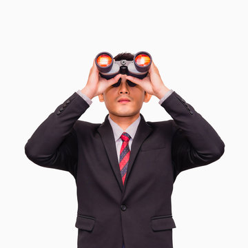 Asian young businessman standing and looking through binoculars