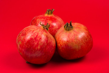 Sweet pomegranate on red background.