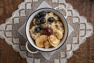 Porridge close-up. Ingredients: oat flakes, banana, blueberries, chia, cinnamon, maple syrup and strawberry jam. Horizontal. Top view. Middle