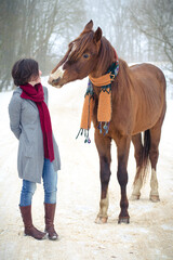 portrait of girl and red trakehner stallion horse with scarf in winter