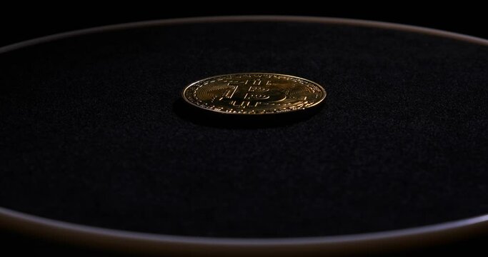 Bitcoin symbol is cast in gold, coin lies on black velvet pedestal and rotates slowly, gold, crypto, new money, wealth, close-up, expensive gift, new era, financial system crash, wealth, investment