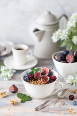 Cottage cheese with figs, berries, honey. Cup of coffee and coffee pot. Breakfast. Wooden table.