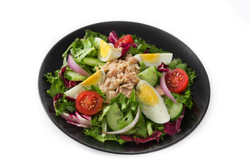 Salad with tuna, egg and vegetables isolated on white background
