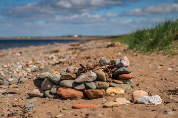 A fireplace of stones for a campfire on the beach, seen near Allonby, Cumbria, England, UK