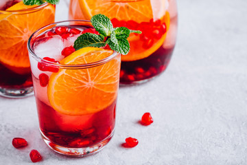 Pomegranate Orange Holiday Punch with ice and mint in glass