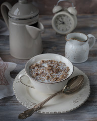 Buckwheat porridge with milk on wooden background.