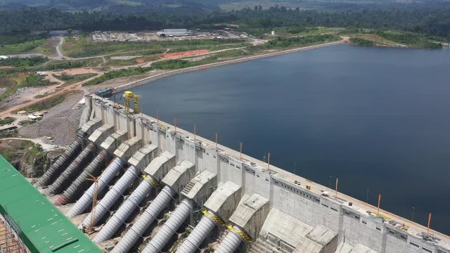 Aerial view of a hydroelectric power dam in Brazil. Pull back dolly shot, high angle.