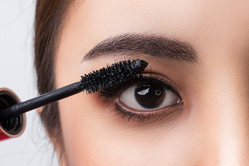 Naklejka premium Close up applying mascara brush on eyelash. Applying cosmetic make up eyelash Extensions. Asian eye make up cosmetics.