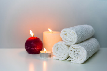 Obraz na płótnie Canvas SPA massage concept photo with candle lights and stack of white towels.
