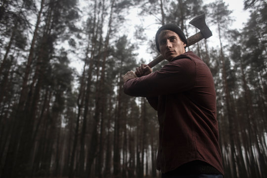  Lumberjack with the ax in the forest.Stylish lumberman getting ready for work. Hard iwork in the forest. Lumberjack chopping a tree. Lifestyle. 