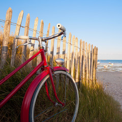 Vieux vélo rouge en bord de mer, vacances sur lîle de Noirmoutier. France