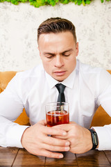 Businessman drinks whiskey at the table