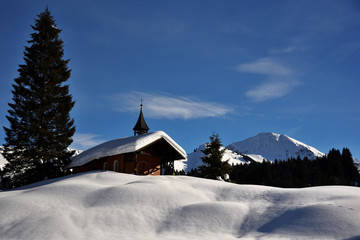 Eine verschneite Winterlandschaft mit Kapelle