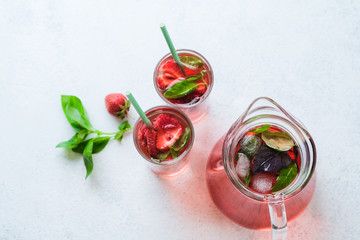 Homemade fresh strawberry lemonade with basil leaves on a light background copy space. Top view.