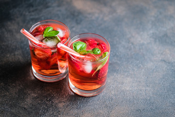 Homemade fresh strawberry lemonade with basil leaves on a dark background copy space.