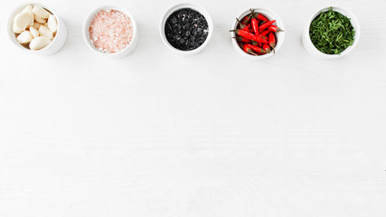 Organic food seasoning assortment. White wooden background.