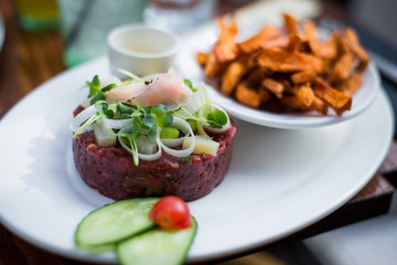 Tartare of beaf with fried potatoes and vegetables 