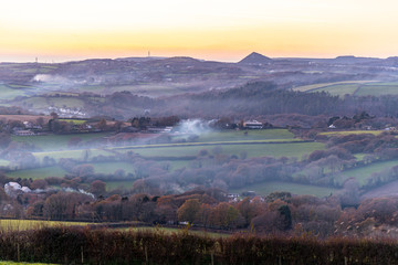 The haze of wood smoke over a Cornish valley in autumn