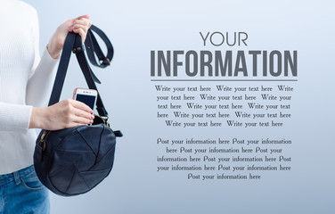 Woman put mobile phone into black bag on gray light background, space for text