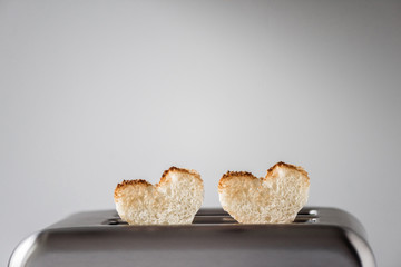 Two heart shaped toast bread roasted toasted in a toaster. Breakfast preparation on Valentine's Day. symbol sign of love. Concept