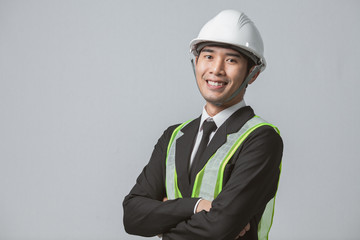 Portrait project engineer cross arm and smiley in suit with safety vest in studio. Asian man smiley...