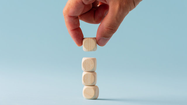 Stacking four blank wooden dices